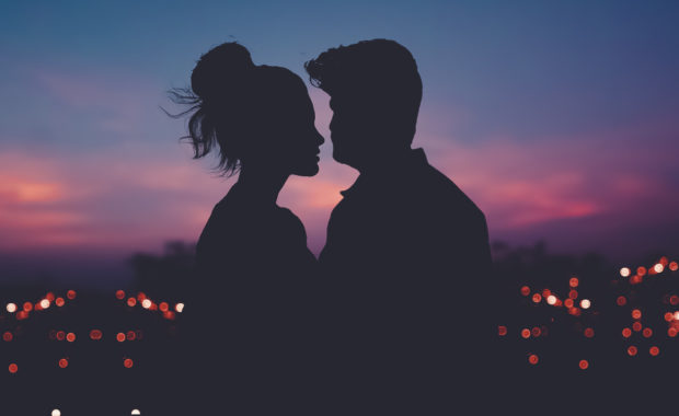 Couple in front of a city at sunset