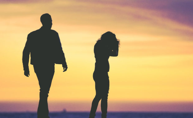 silhouette of couple arguing at sunset
