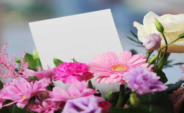 flower arrangements of pink, purple, white, and yellow flowers with a card in the middle of them