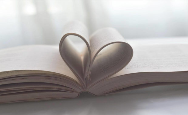 open book with pages folded into a heart in the middle
